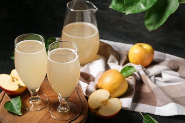 Siyah arka planda gözlük ve bir sürahi taze elma kvass.