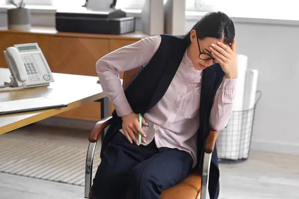 stock image Young businesswoman suffering from severe abdominal pain in office