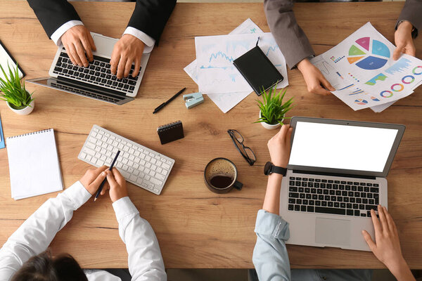 Business team working with laptops and documents during meeting in office, closeup