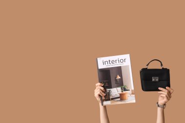 Şarjörlü kadın elleri ve kahverengi arka planda şık bir çanta.