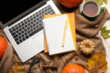 Dizüstü bilgisayar, çay fincanı ve süveter üzerine sonbahar dekoru, üst görünüm.