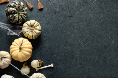 Koyu renk arka planda Cadılar Bayramı için taze balkabağı ve süsleme kompozisyonu