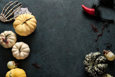 Koyu renk arka planda Cadılar Bayramı için taze balkabağı ve süsleme kompozisyonu