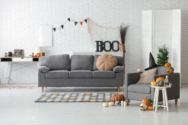 Cadılar Bayramı partisi için dekore edilmiş gri kanepeli şık bir oturma odası.