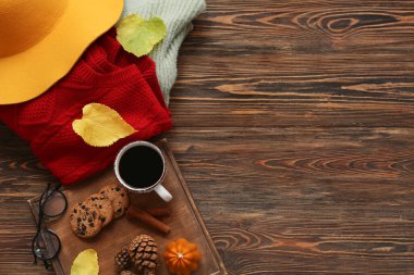 Kahveli, kurabiyeli, süveterli ve sonbahar yapraklı kompozisyon ahşap arka planda