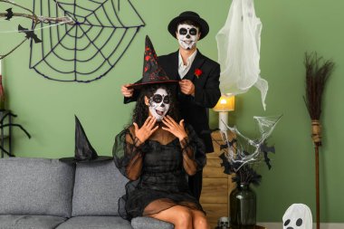 Young couple dressed for Halloween at home clipart