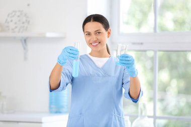 Araştırma laboratuarında profesyonel cam numuneleri olan mutlu bayan bilim adamı.