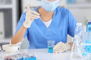 Profesyonel cam takımlı genç bir bilim adamı araştırma laboratuarında su kalitesini inceliyor.