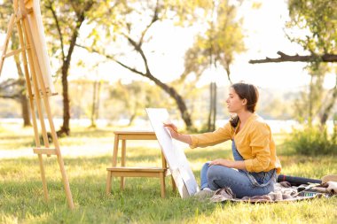 Parkta kalem çizimi yapan kadın sanatçı
