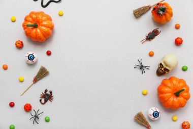 Gri arka planda Cadılar Bayramı için farklı dekorasyon ve şekerler içeren kompozisyon