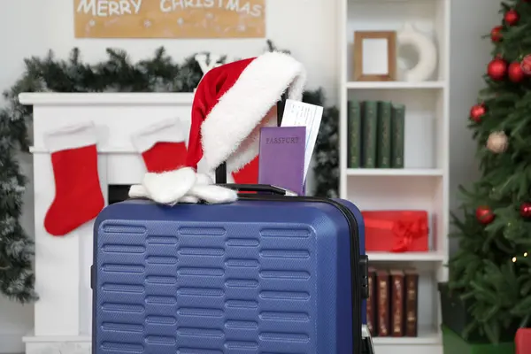 stock image Suitcase with Santa hat, mittens and passport in living room