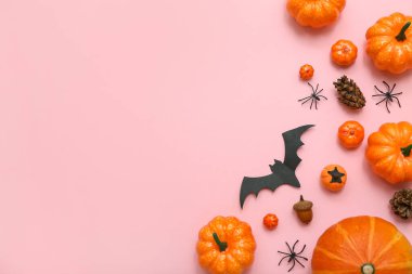 Pembe arka planda Cadılar Bayramı için farklı dekorasyonlara sahip kompozisyon