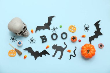 Renkli arkaplanda Cadılar Bayramı için kelime BOO, süslemeler ve şekerler içeren kompozisyon