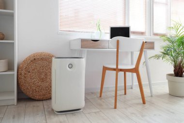 Ofisteki masanın yanında hava nemlendirici var.