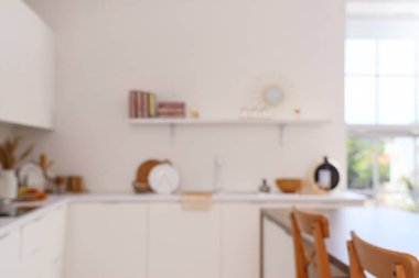 Beyaz tezgahları ve rafları olan bulanık mutfak manzarası