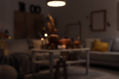 Cadılar bayramı için dekore edilmiş karanlık oturma odası bulanık. Parlayan lamba, kanepeler ve gece masası.