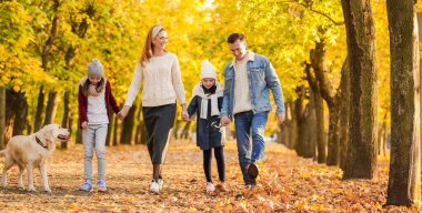 mutlu bir aile sonbahar parkta yürüyüş