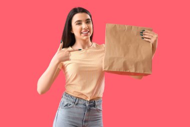 Kırmızı arka planda bir torba suşiye işaret eden genç bir kadın.