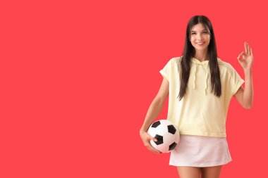 Futbol toplu genç bayan kırmızı arka planda iyi görünüyor