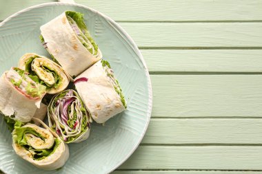 Yeşil ahşap zemin üzerinde soğan ve yumurta ile lezzetli lavaş ruloları