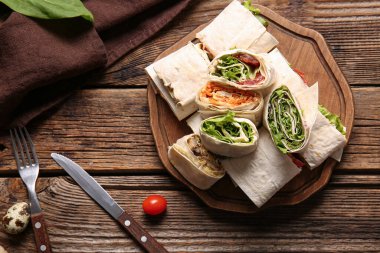 Ahşap arka planda sebzeli ve sebzeli lavaş ruloları.