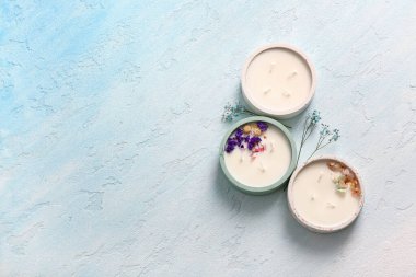 Mavi arka planda mumları ve çiçekleri olan tutucular