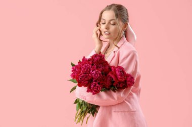 Pembe arka planda şakayık çiçekleri olan güzel bir kadın.