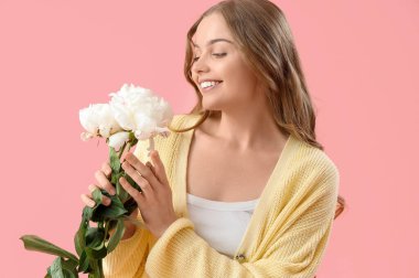 Pembe arka planda şakayık çiçekleri olan güzel bir kadın.