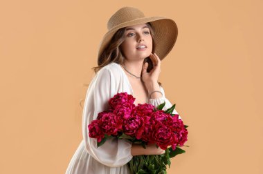 Bej arka planda şakayık çiçekleri olan güzel bir kadın.