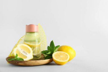 Beyaz arka planda salatalıklı ve naneli bir şişe limonata.