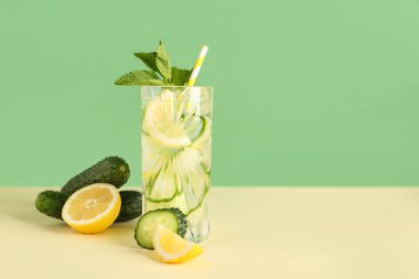 Bir bardak salatalıklı limonata ve renkli arkaplanda nane şekeri.