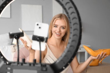 Güzel genç moda blogcusu yeni alımlar hakkında video kaydediyor.