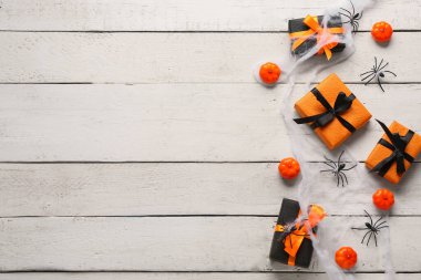 Ahşap arka planda Cadılar Bayramı süslemeleri olan hediye kutuları