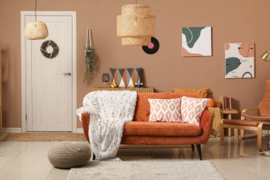 Oturma odasının içinde kırmızı kanepe ve puf.