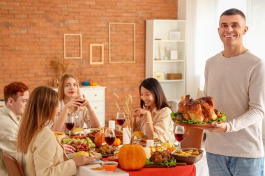 Şükran Günü 'nde hindi yiyen genç adam.