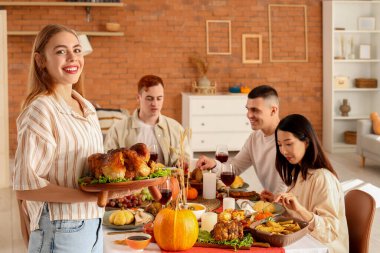 Şükran Günü 'nde hindiyle yemek yiyen genç kadın.