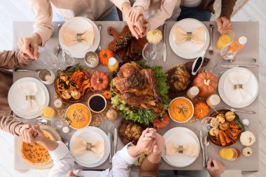 Mutlu bir aile Şükran Günü 'nde şenlik masasında yemek yiyor.