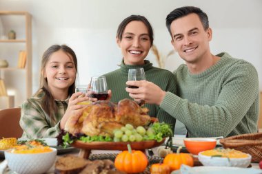 Şükran Günü 'nde ailesiyle birlikte kutlama masasında yemek yiyen küçük bir kız.