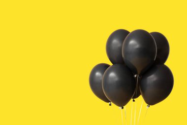 Sarı arka planda siyah hava balonları. Kara Cuma konsepti