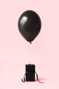 Pembe arka planda hava balonu olan bir hediye kutusu. Kara Cuma konsepti
