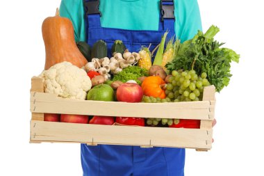 Beyaz arka planda bir kutu sebzeli erkek çiftçi, yakın plan.