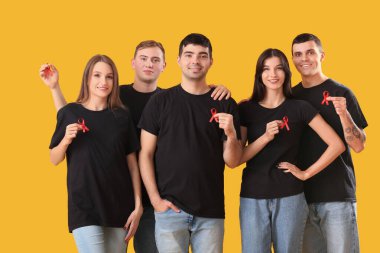 Sarı arka planda kırmızı kurdeleli bir grup genç. Dünya AIDS Günü konsepti