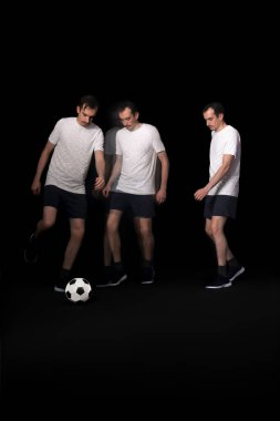 Siyah zemin üzerinde top oynayan futbolcu