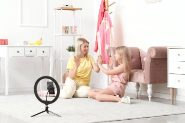 Güzel bayan blogcu ve kızı evde video kaydediyor.