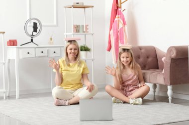 Güzel kadın blogcu ve kızı evde video kaydı yapıyorlar.