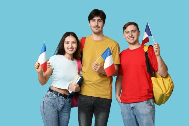 Mavi arka planda Fransız bayrakları olan bir grup öğrenci