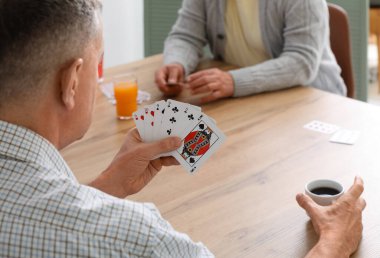 İçkili yaşlı adamlar evde kağıt oynuyorlar, kapatıyorlar.