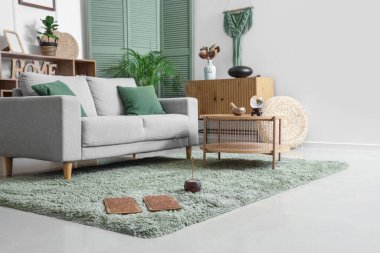 Oturma odasındaki halıya aromalı Sadhu tahtası.