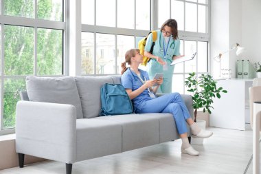 Klinikte tablet bilgisayar kullanan kadın stajyerler.