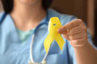 Doktor sarı kurdele tutuyor, yakın plan. Sarkoma konsepti.